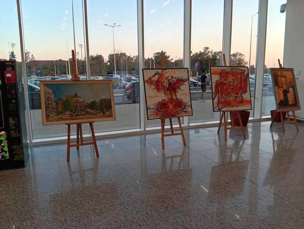 Paintings on easels along the glass front