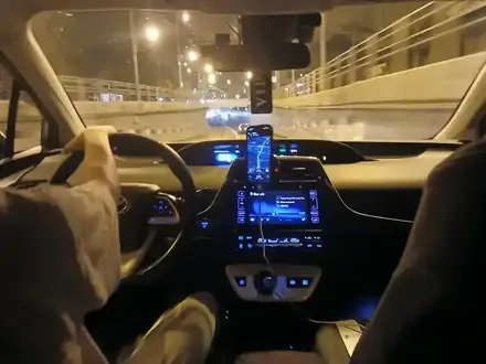 A Bolt ride through Craiova at night, seen from the back seat — the driver's phone on the dash showing the route