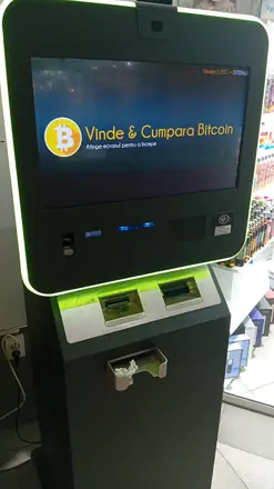 A General Bytes unit inside a shop: screen, note acceptor, contactless pad, print slot. The ticker was quoting a sell rate around 337,000 lei per BTC in late August 2026