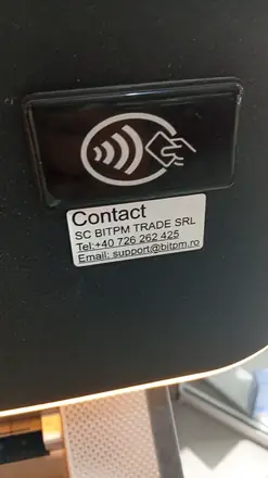 The operator label on the same machine — who to ring if it eats your note