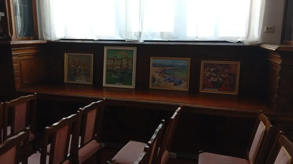 Small paintings stood along the panelling below the windows