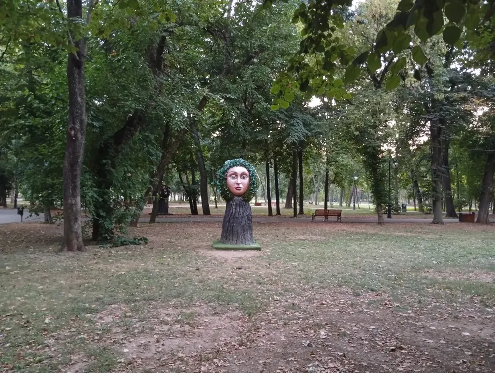 A carved face set into a tree stump beside one of the paths