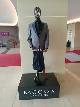 Bagossa Tailoring display in the Ramada Craiova lobby — a grey suit with black lapels on a tailor’s dummy