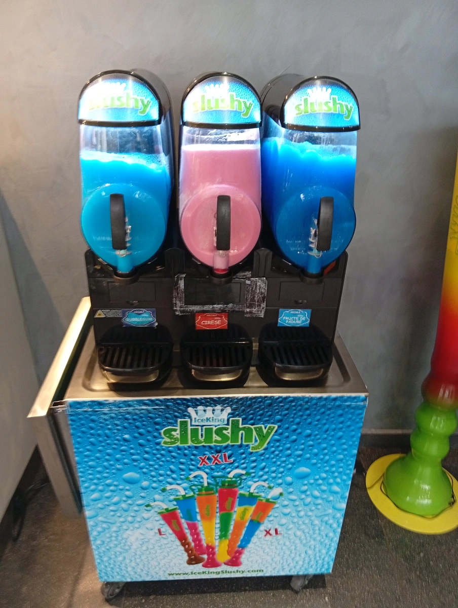 A slushy machine by the seating — bubblegum, cherry and forest fruit