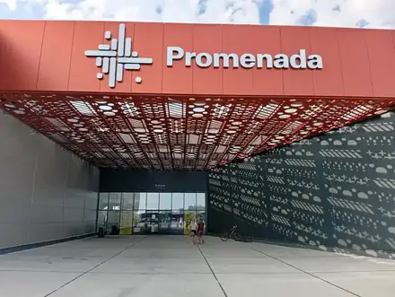The main entrance of Promenada Mall, Craiova, under its perforated red canopy