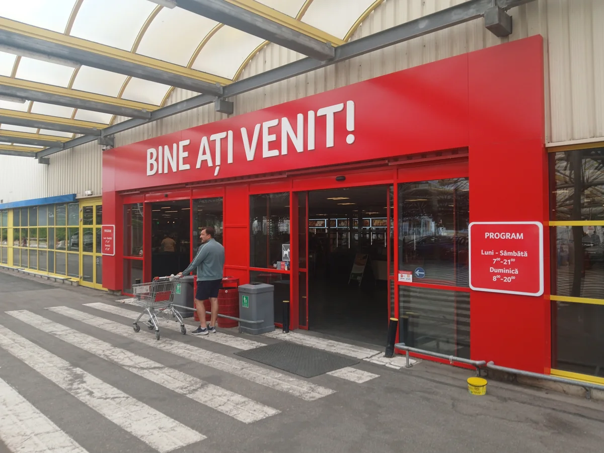The entrance — opening hours on the red board beside the doors. 26 September 2026
