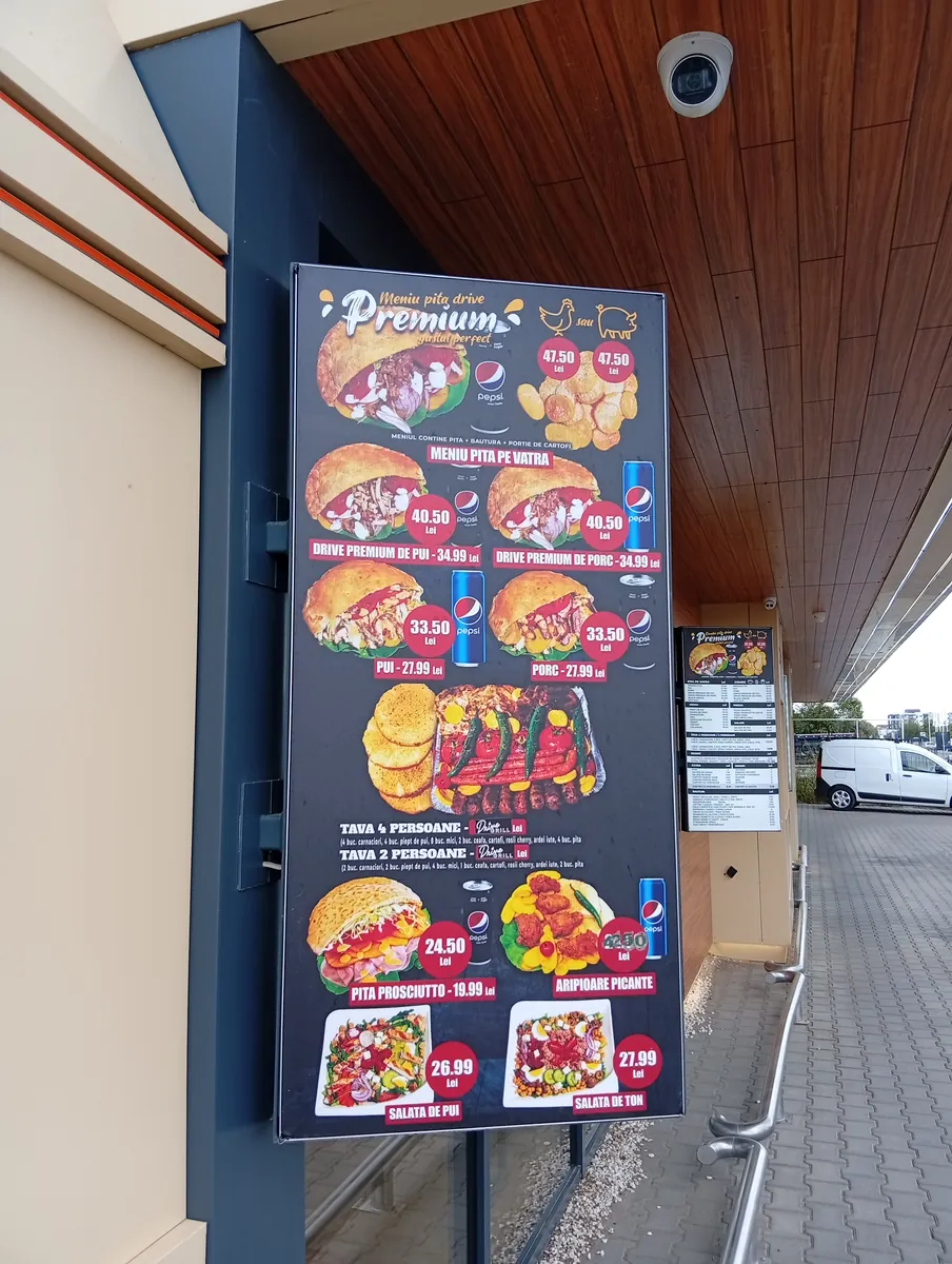 Outdoor menu board at Drive Grill, Craiova: Premium pita menus at 47.50 lei, hearth-baked chicken and pork pita, grill trays and salads, 22 September 2026
