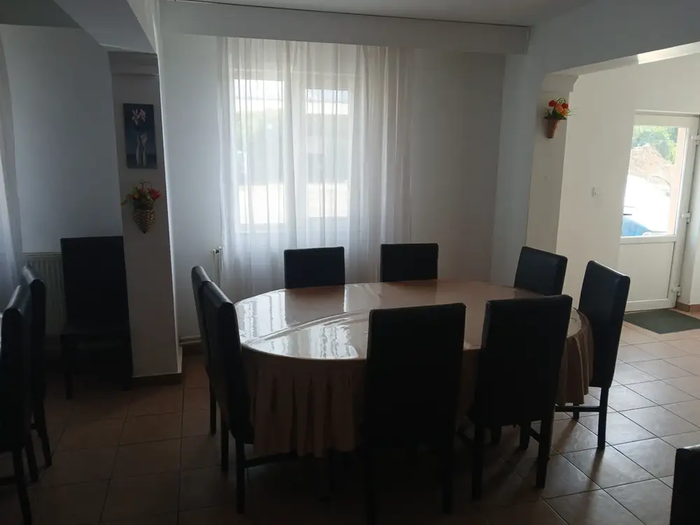 A table laid for ten, the window onto the street behind it