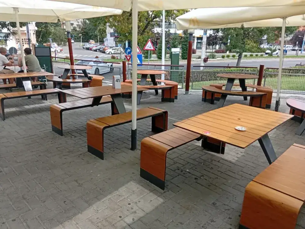 The terrace: long benches, parasols, and the street beyond