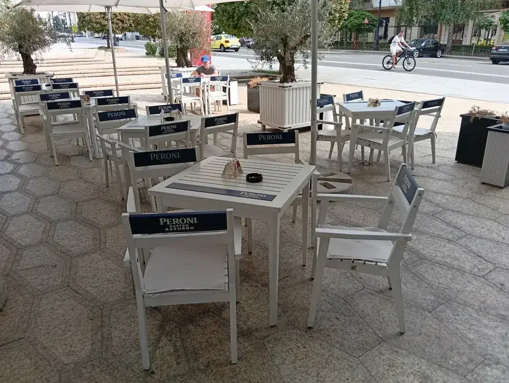 The terrace, umbrellas and olive trees, facing the square